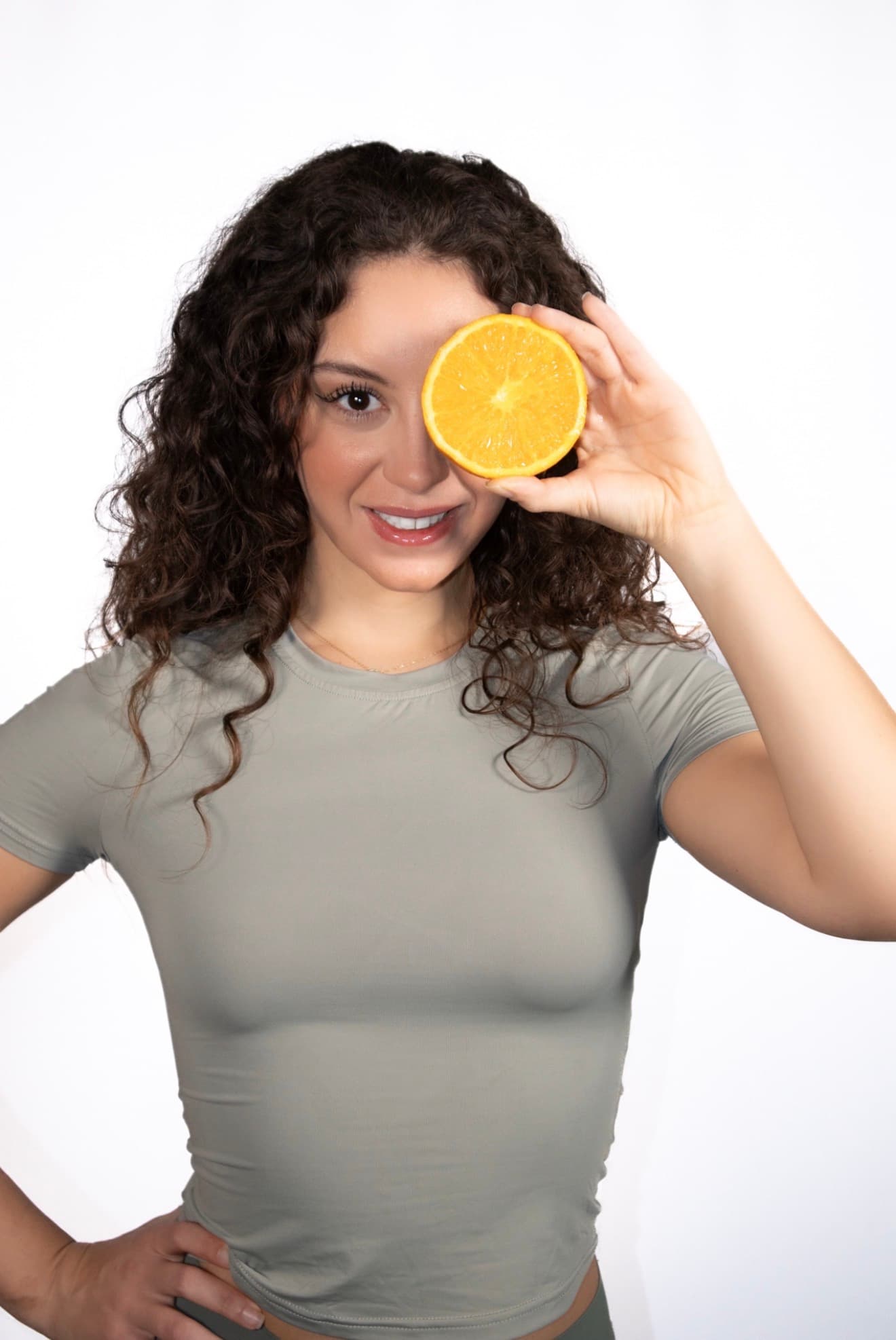 Tina, nutrition coach, holding a fresh orange slice